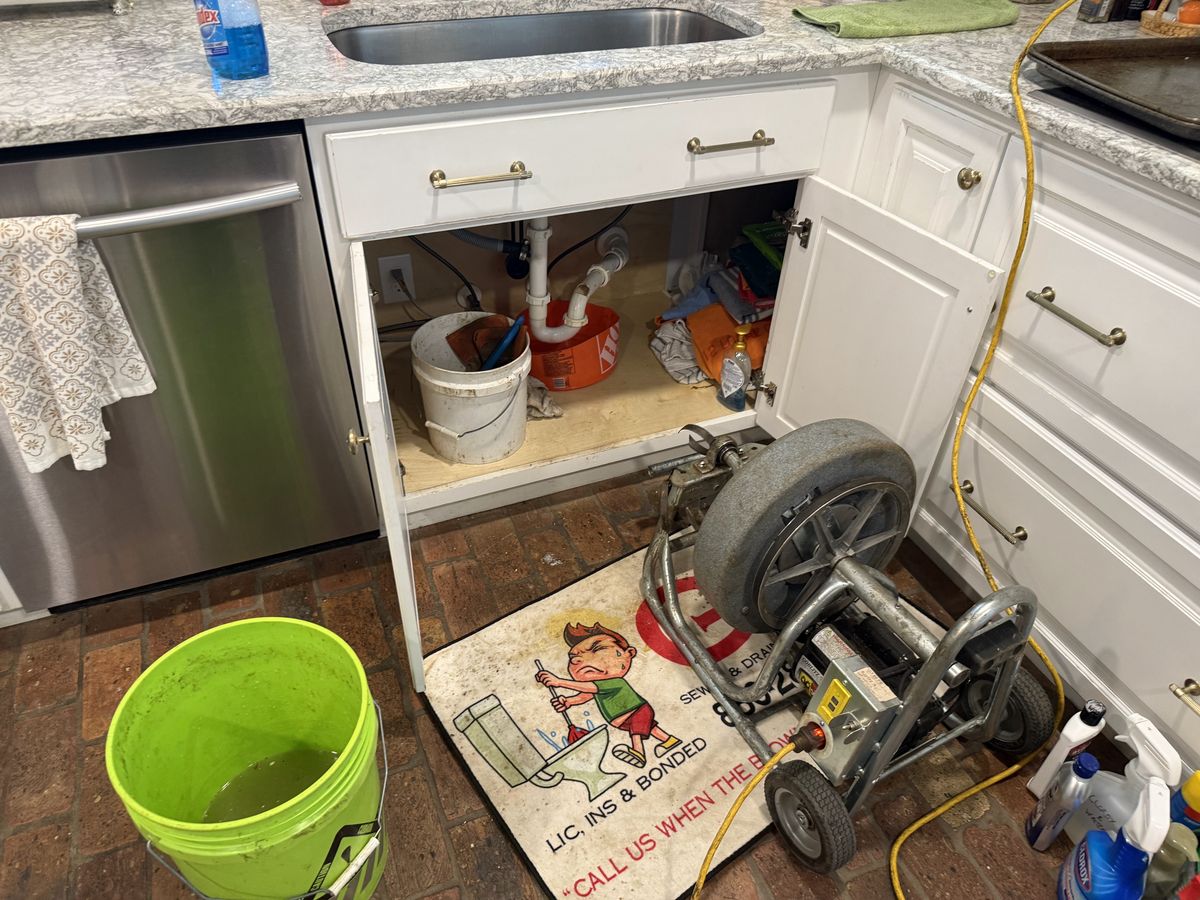 G&R drain machine set up at a kitchen sink cabinet during a real service call