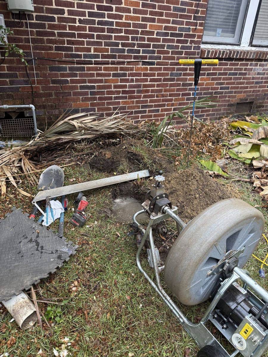 G&R sewer machine set up at an outdoor cleanout beside a brick Pensacola home