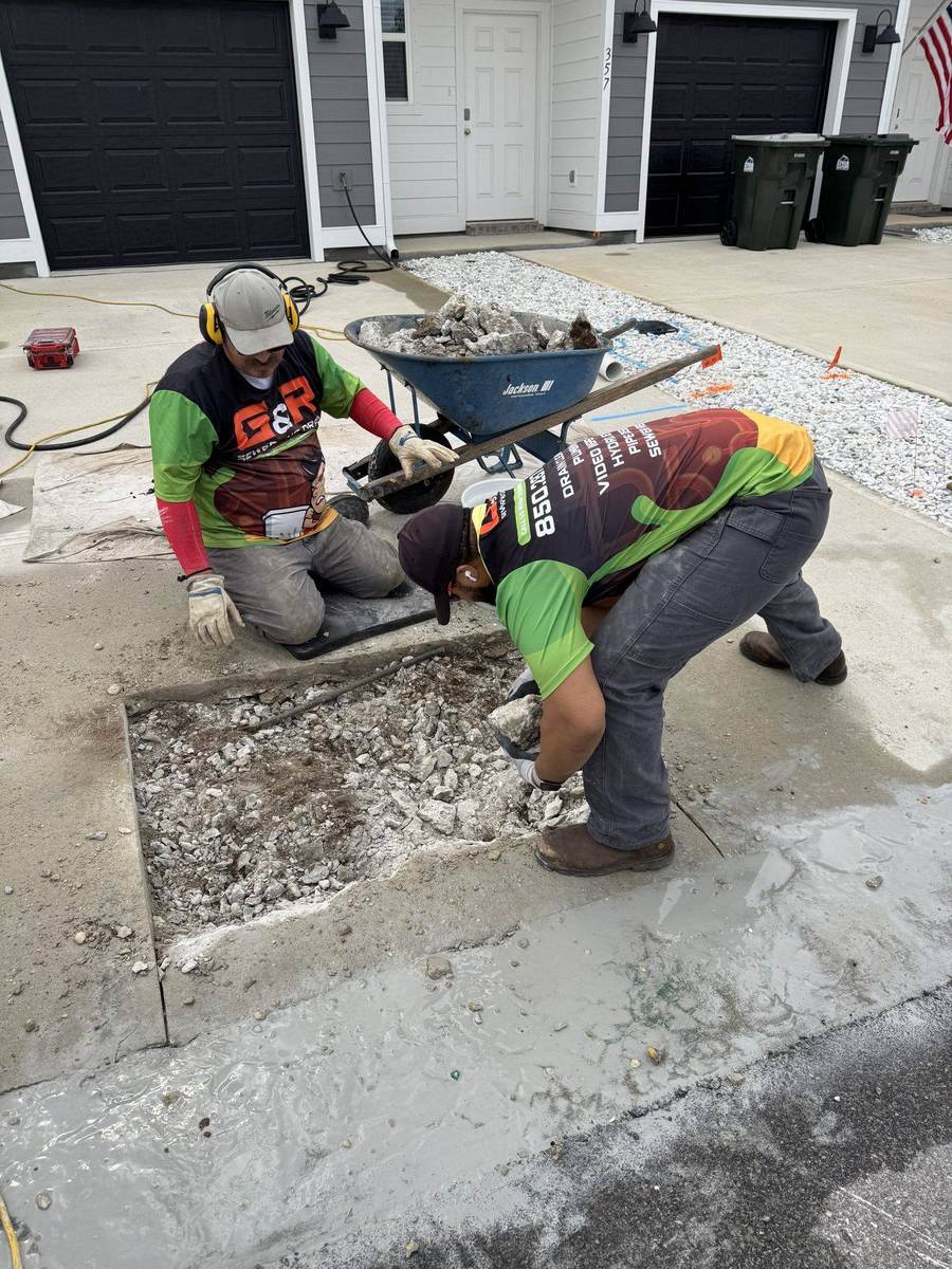 A smiling G&R Sewer and Drain technician in a branded shirt on a real Pensacola job